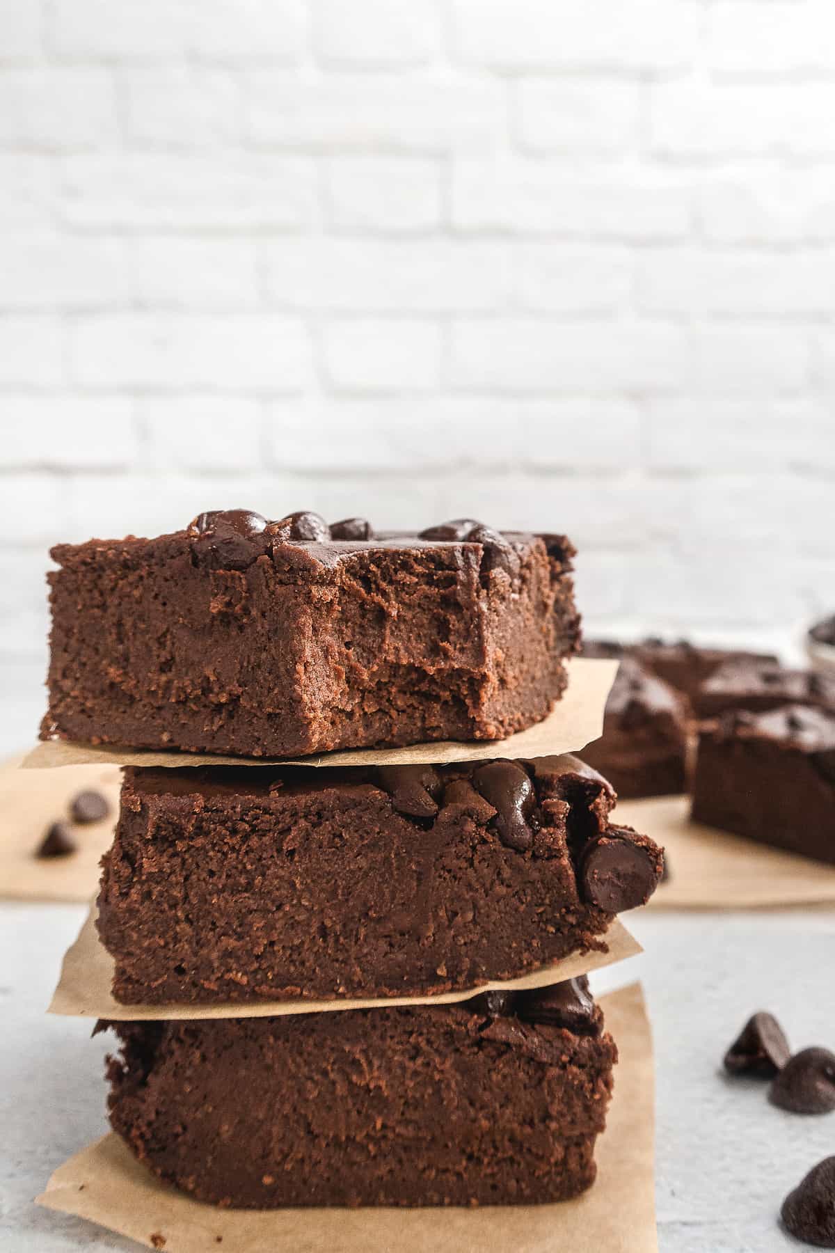 stack of three brownies on parchment paper