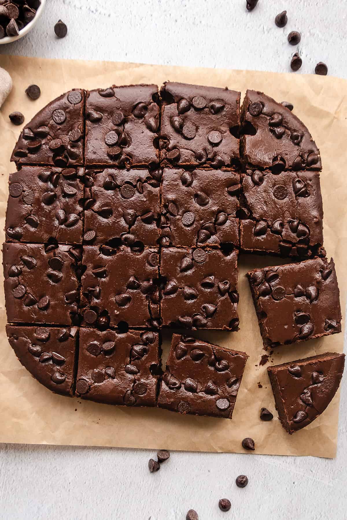sliced brownies with chocolate chips on parchment paper.
