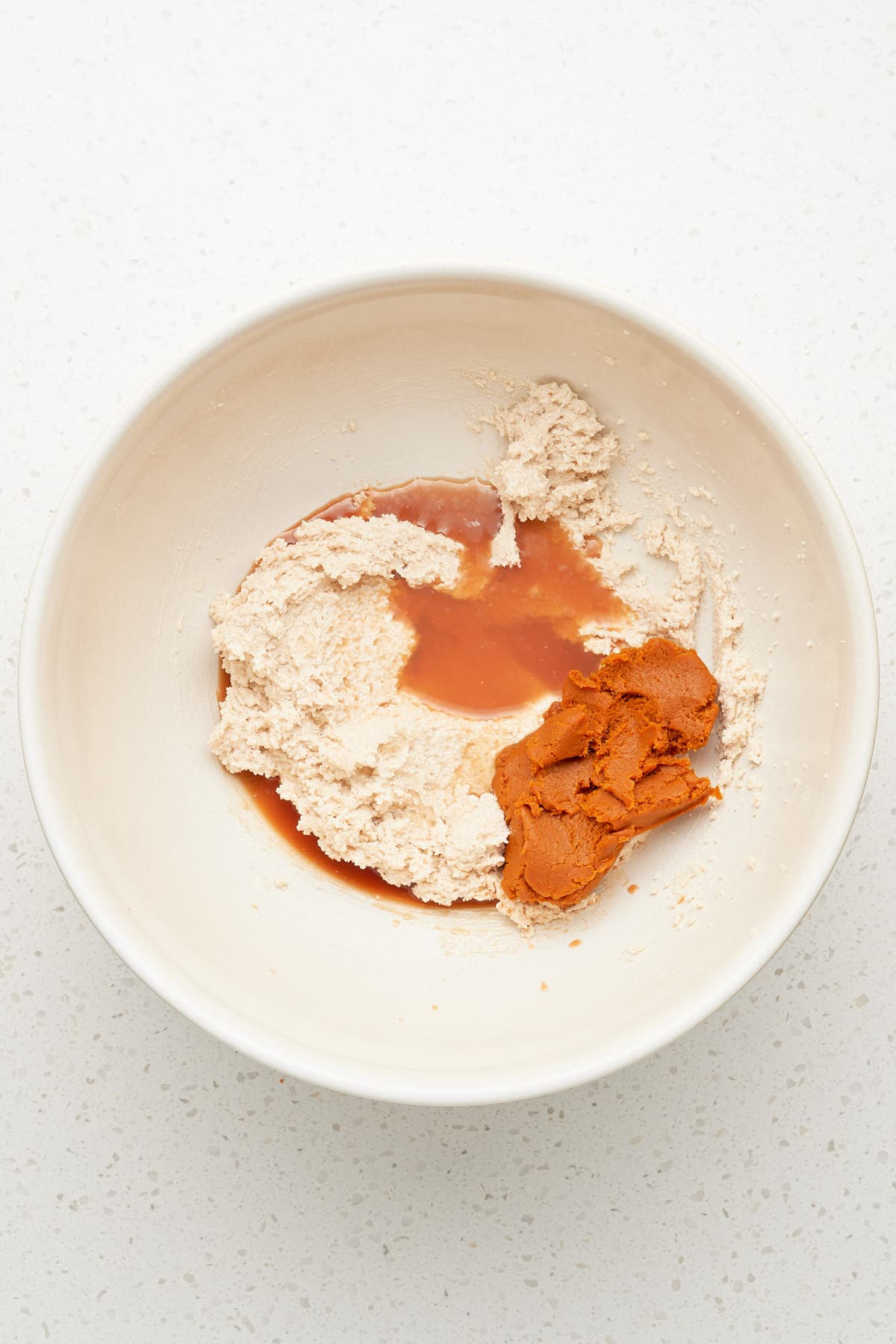 creamed vegan butter, vanilla and pumpkin puree in a bowl.