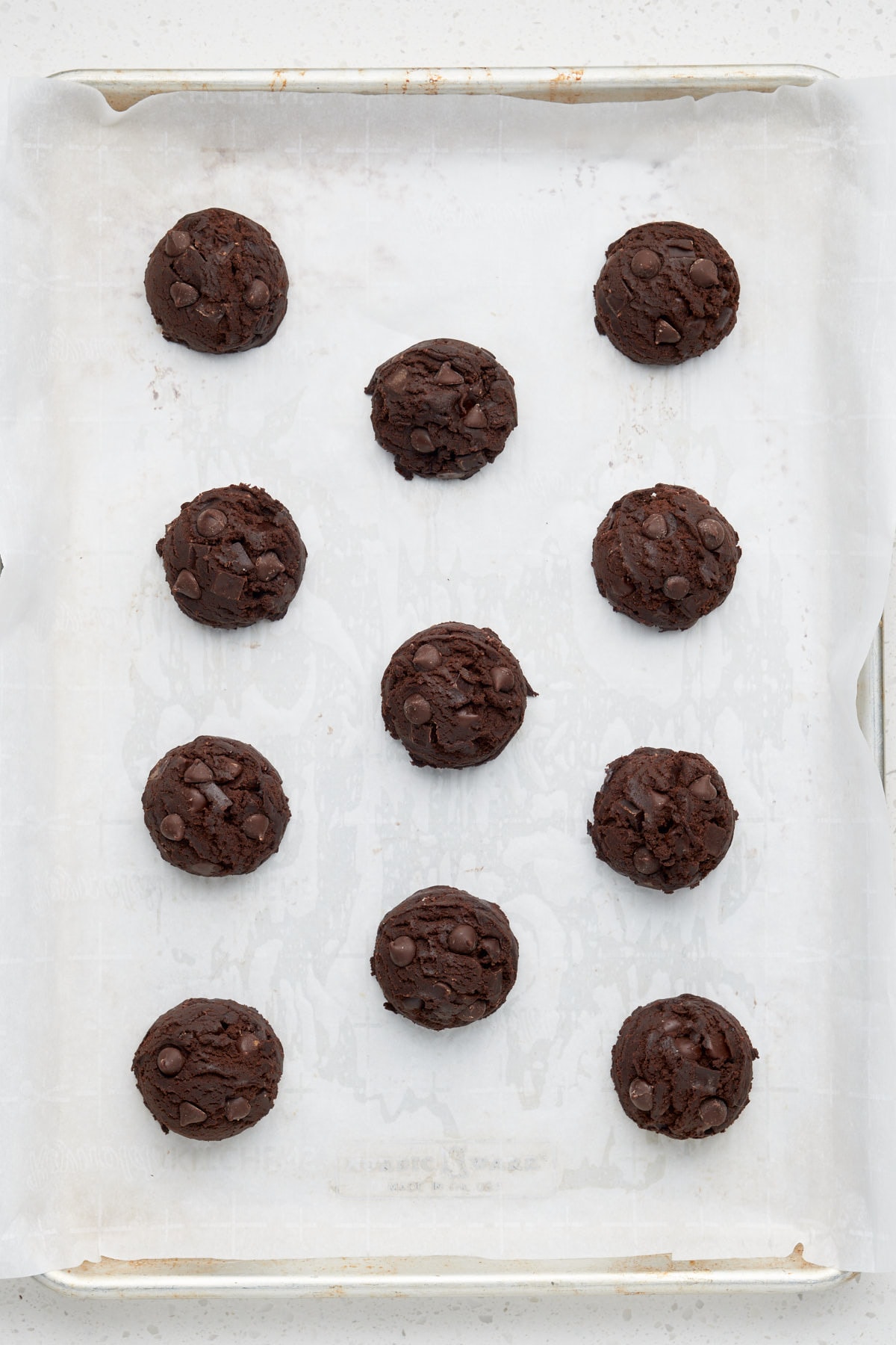 scooped unbaked double chocolate chip cookie dough portions on a baking tray.