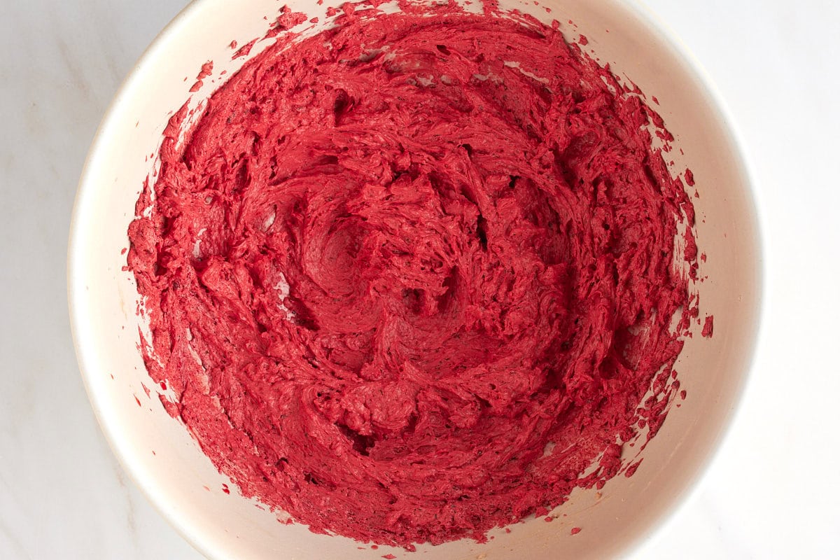 Creamed dairy-free butter and sugar mixed with red food coloring in a bowl.